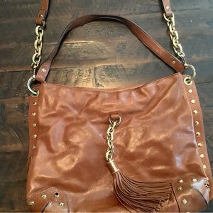Michael Kors tan cross body purse with tassels.